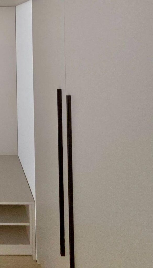 Detail čiernych kovových úchytiek na skrini vo vstupnej chodbe na mieru